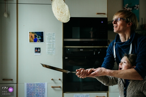 Belgien wirft mit seiner Tochter während eines Wallonie-Tages in der Life-Fotografie-Session einen Pfannkuchen in die Luft