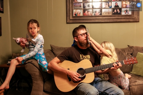 San Francisco, California documentary family photography showing the daughter messing with Dad while he plays guitar