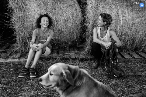 Perpignan documentary family photography chronicling a family sitting by hay bales noting that Dogs dont laugh
