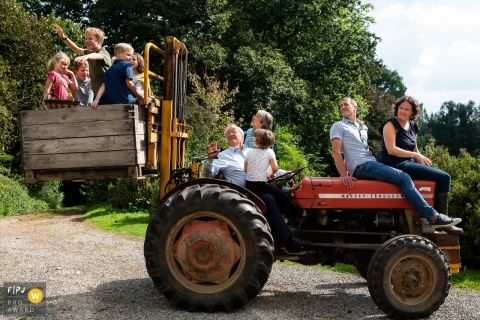 East Flanders family photography documenting a family ride on a tractor with a crate lift at the rear