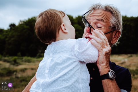 Amsterdam family photography documenting Granddaughter reaching for grandpas glasses
