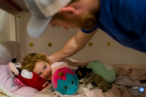 Un photographe de famille documentaire d'Atlanta, en Géorgie, a capturé un père bordant sa fille pour se coucher la nuit