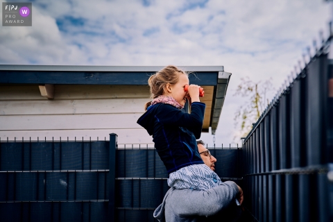 A Bonn, Germany documentary family photographer captured the spectators looking over the fence with binoculars 