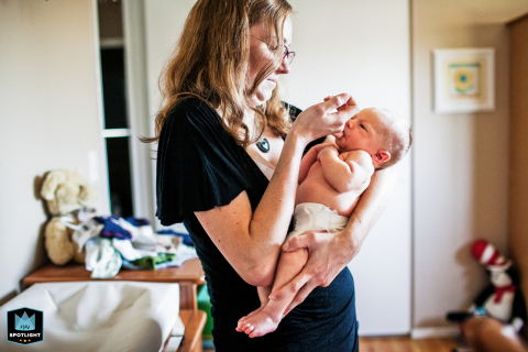 In San Francisco, California, a tender moment unfolds as a mom holds her new baby, gently placing her pinky finger in the baby's mouth, highlighting their intimate bond.