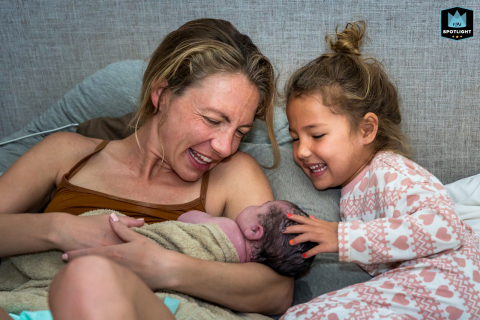 In Ventura, California, a joyful moment unfolds as a big sister meets her new sibling for the first time, all smiles shared with mom.