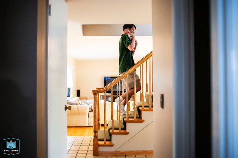 In a San Francisco home, a tender moment unfolds as dad carefully carries his newborn baby upstairs, capturing the quiet intimacy of new parenthood.