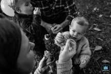 In Ventura, California, a black-and-white high angle shot captures a little girl eagerly reaching for bubbles from her mama, wonder and joy on her face.