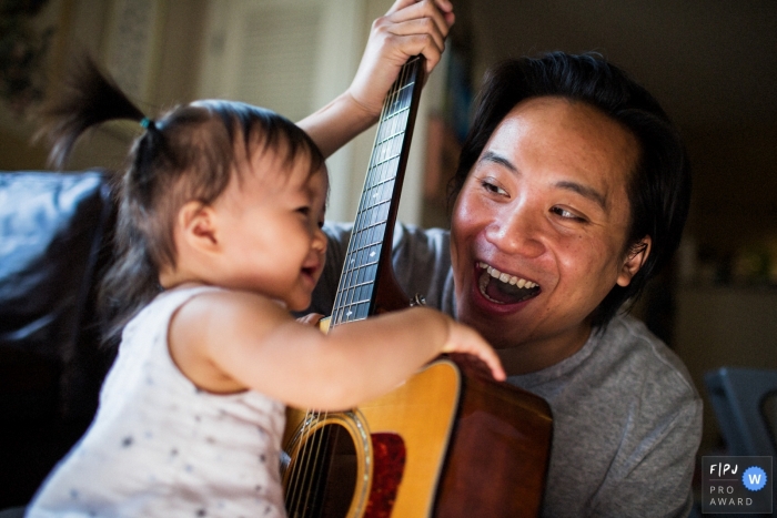 Le photojournaliste de la famille de San Francisco a capturé cette photo d'un père aidant sa fille en bas âge à gratter une guitare acoustique