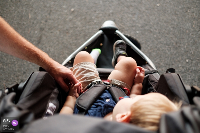 Cette image d'un tout-petit endormi dans une poussette en saisissant la main de son père a été capturée par un photojournaliste de la famille d'Atlanta.