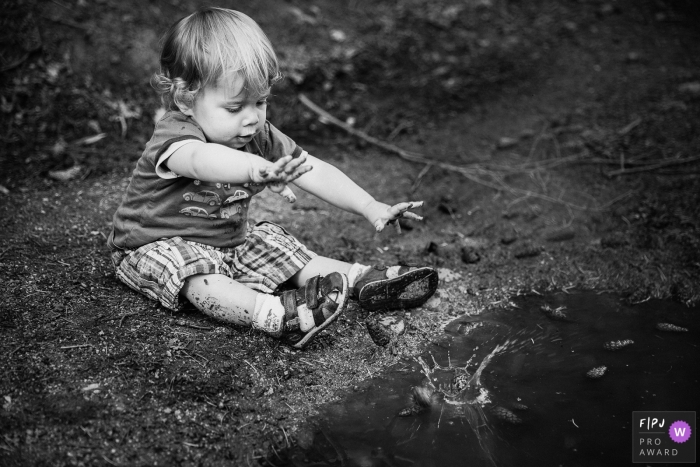 Een jongen gooit een steen in water in deze zwart-witfoto door een fotojournalist van de familie in Lyon.