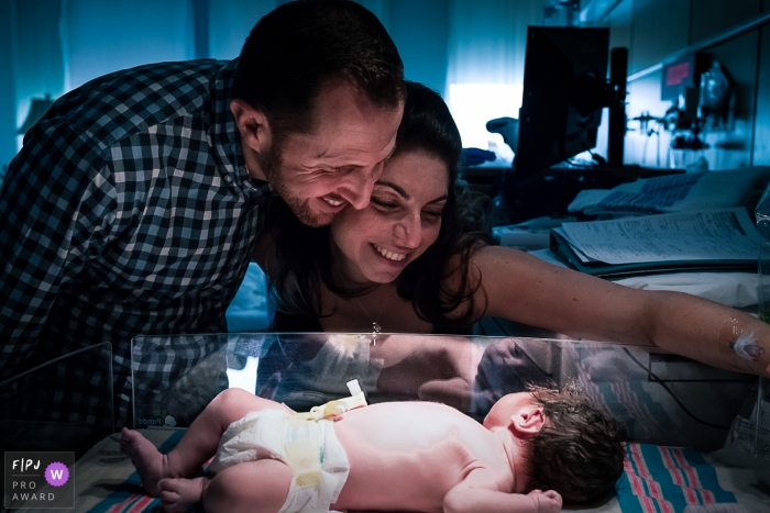 Photo by: <a href="https://www.fpja.com/documentary-family-photography-contests/ana-elena-alvarez/washington-dc/2042636">Ana Elena Alvarez - United States</a> A new mother and father visit their newborn in the hospital in this photo by a Washington, D.C. birth photographer.