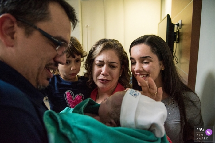 Photo by: <a href="https://www.fpja.com/documentary-family-photography-contests/rebeca-de-lima-oliveira-bianca/esp%C3%ADrito-santo/2063551">Rebeca de Lima Oliveira Bianca - Brazil</a> A family gets to meet their newest family member in the hospital in this photo by an award-winning Espirito Santo, Brazil birth photographer.