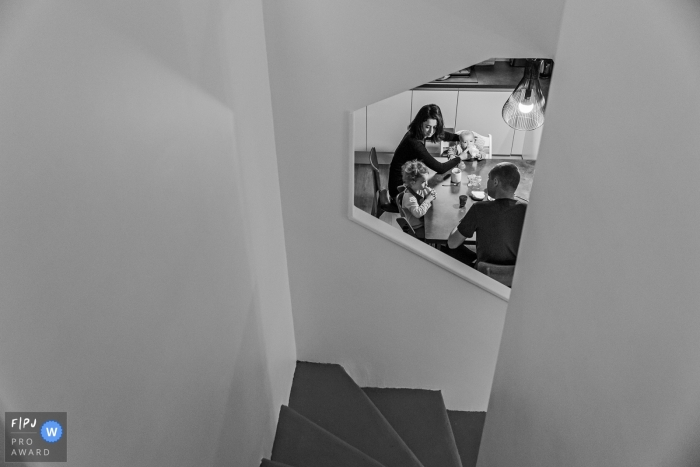 A family enjoys a meal together in the kitchen downstairs in this documentary-style family image recorded by a Haute-Garonne photographer. 