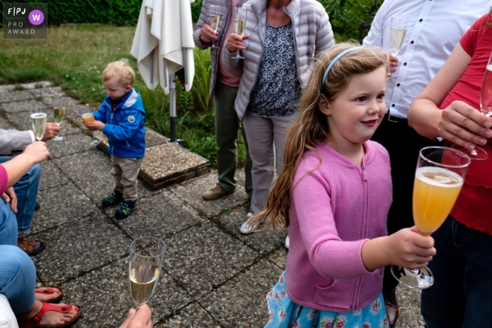 A family enjoys champagne outside as two children drink juice from champagne glasses in this documentary-style family photo captured by a Berlin, Germany photographer. 