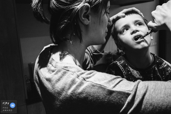 A mother brushes her son's teeth in this photo by an Antwerpen award-winning family photographer. 