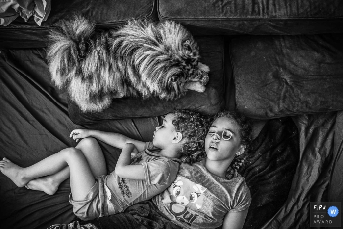 Two siblings sleep next to each other as their dog lays by them in this photograph by a Sao Paulo, Brazil documentary family photographer. 