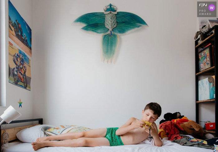 Un garçon regarde sa caméra alors qu'il est couché sur une photo primée d'un photographe de la famille de l'Hérault.