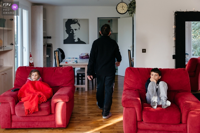 Photo by: <a href="https://www.fpja.com/documentary-family-photography-contests/estelle-chhor/h%C3%A9rault/2066041">Estelle Chhor - France</a> A boy and girl sit in separate chairs watching TV in this picture captured by a Herault family photojournalist.