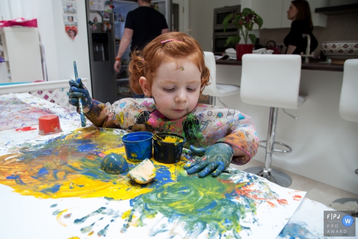 Photo by: <a href="https://www.fpja.com/documentary-family-photography-contests/felicity-aitken/scotland/2066291">Felicity Aitken - United Kingdom</a> A little girl makes a mess while painting in this photograph by a Scotland documentary family photographer.