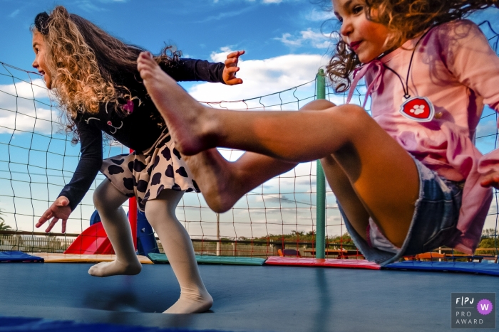 Photo by: <a href="https://www.fpja.com/documentary-family-photography-contests/renato-mello/rio-grande-do-sul/2066431">Renato Mello - Brazil</a> Two girls jump on a trampoline in this award-winning photo by a Rio Grande do Sul, Brazil family photographer.