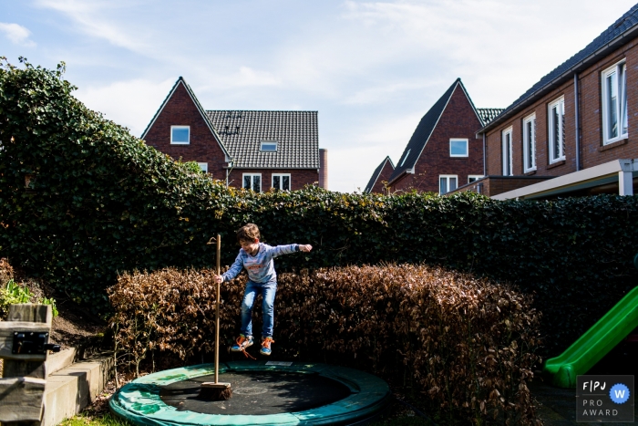 Photo by: <a href="https://www.fpja.com/documentary-family-photography-contests/lavinia-nitu/modena/2067336">Lavinia Nitu - Italy</a> A boy jumps on a trampoline while holding a broom in this award-winning photo by a Modena family photographer.