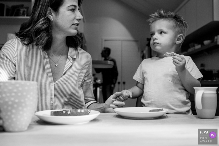 Photo by: <a href="https://www.fpja.com/documentary-family-photography-contests/casie-zalud/boulder/2067846">Casie Zalud - United States</a> A son looks questioningly at his mother as he eats his breakfast in this documentary-style family image recorded by a Boulder, CO photographer.