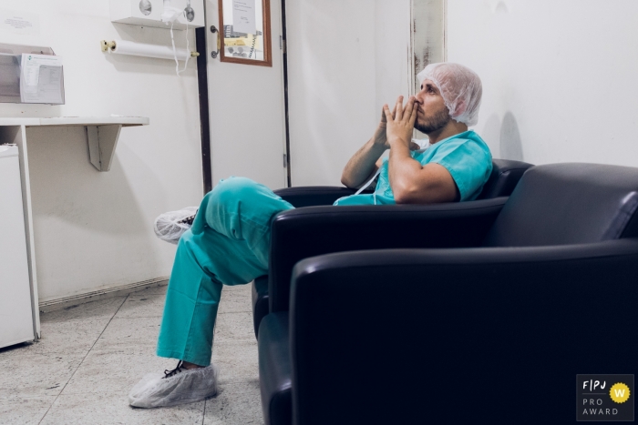 A father waits anxiously in the hospital as his wife gives birth in this photo captured by a Rio de Janeiro, Brazil documentary birth photographer.