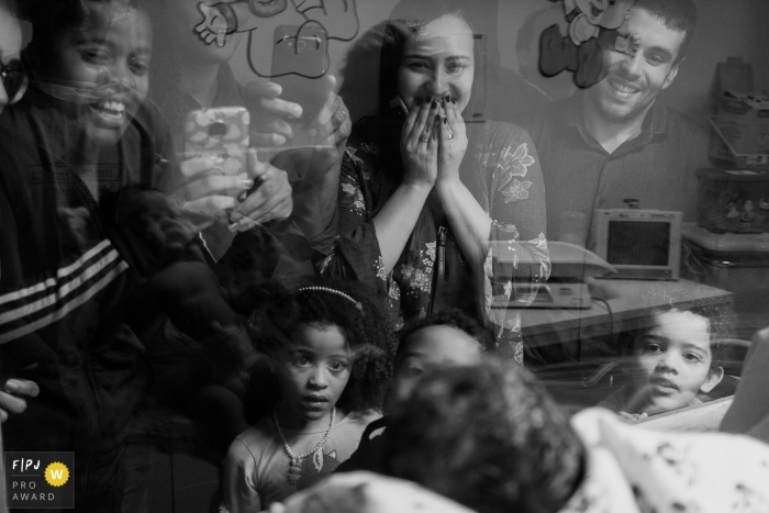 Photo by: <a href="https://www.fpja.com/documentary-family-photography-contests/luciana-bello-vermelho/rio-de-janeiro/2068046">Luciana Bello Vermelho - Brazil</a> A family visits their newest member in the hospital in this black and white image recorded by a Rio de Janeiro, Brazil birth photographer.