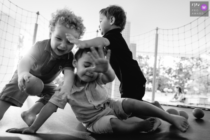 Photo by: <a href="https://www.fpja.com/documentary-family-photography-contests/thiago-braga/florianopolis/2068226">Thiago Braga - Brazil</a> Three little boys play on a trampoline in this award-winning photo by a Florianopolis family photographer.