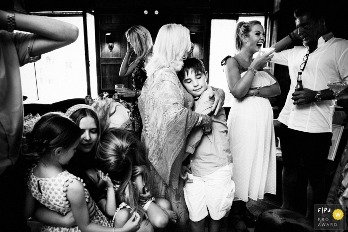 A son hugs his mother during a family gathering in this photo by a London, England award-winning family photographer. 