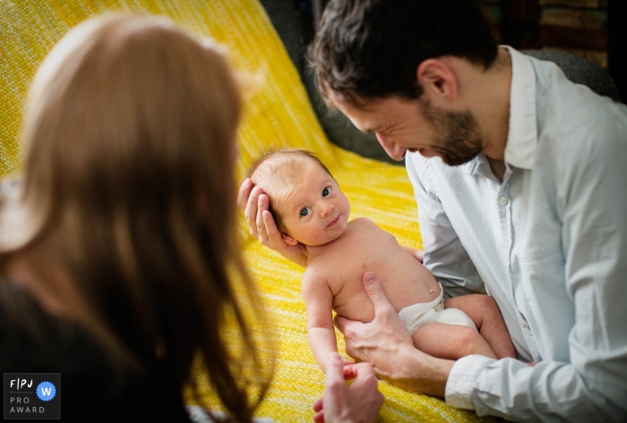 Un père tient son bébé qui lève les yeux vers sa mère sur cette photo créée par un photojournaliste de la famille de Londres, en Angleterre.