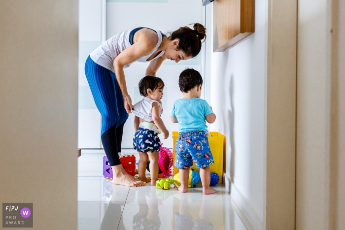 A mother helps her child get dressed in this FPJA award-winning picture by a Sao Paulo, Brazil family photographer.