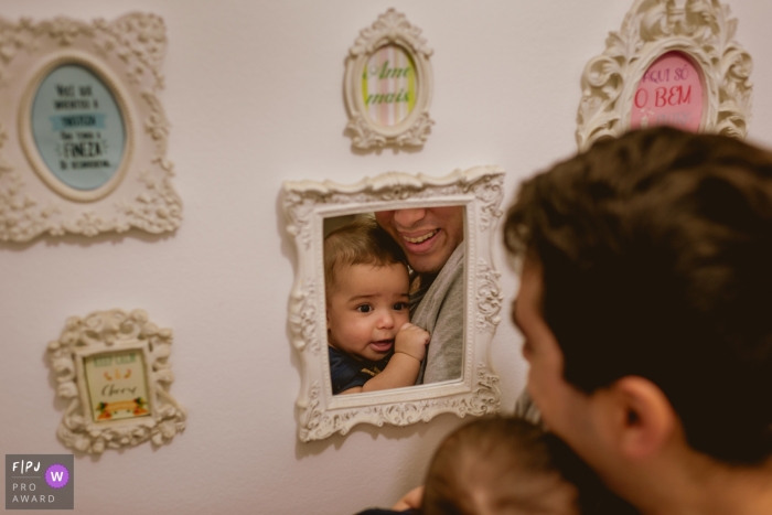 Photo by: <a href="https://www.fpja.com/documentary-family-photography-contests/fabio-souza/rio-de-janeiro/2069066">Fabio Souza - Brazil</a> A father and son look in a mirror on the wall in this picture captured by a Rio de Janeiro, Brazil family photojournalist.