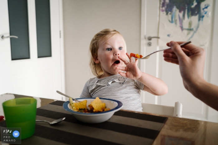 Photo by: <a href="https://www.fpja.com/documentary-family-photography-contests/saskia-moerman/noord-brabant/2069726">Saskia Moerman - Netherlands</a> A little girl does not want to eat her lunch and pushes the fork away in this image created by a Netherlands family photographer.