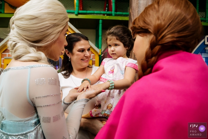Photo by: <a href="https://www.fpja.com/documentary-family-photography-contests/raquel-cid/s%C3%A3o-bernardo-do-campo/2069791">Raquel Cid - Brazil</a> A mother holds her daughter as she meets Elsa and Anna from Frozen in this picture captured by a Sao Paulo family photojournalist.