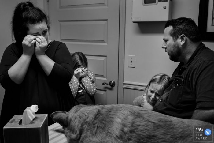 Photo by: <a href="https://www.fpja.com/documentary-family-photography-contests/julie-ambos/key-west/2070756">Julie Ambos - United States</a> A family cries at the veterinarian's office as they say goodbye to their dog in this FPJA award-winning image captured by a Key West, FL family photographer.