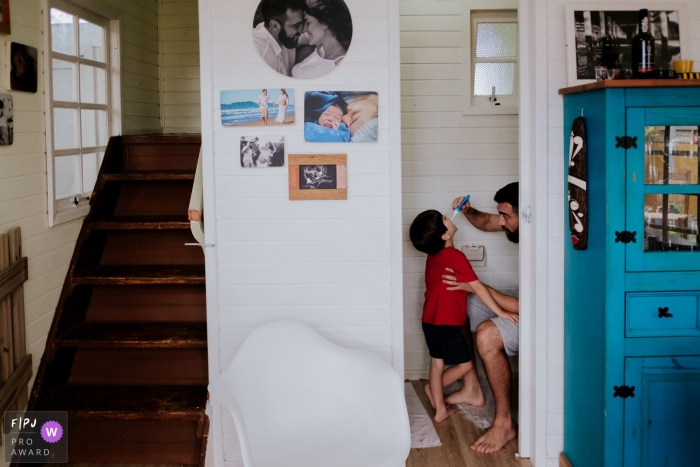 Un père brosse les dents de son fils sur cette photo d'un photographe de famille primé à Florianopolis.