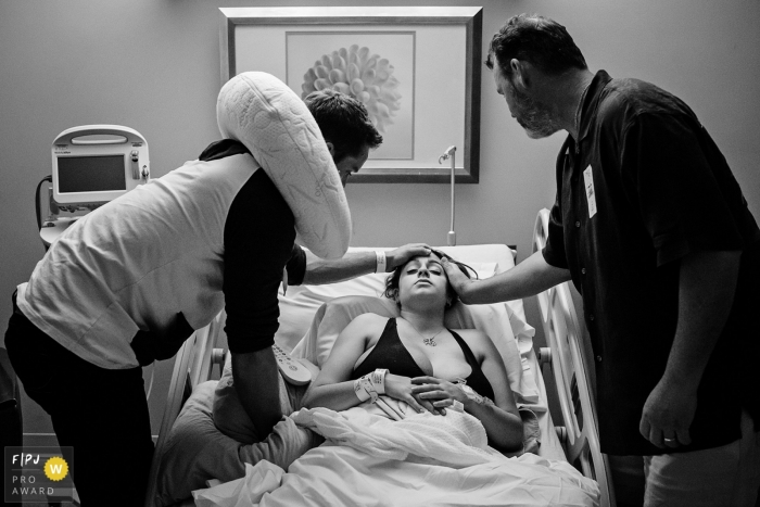 Photo par: Julie Ambos - États-Unis Une famille soutient une femme à l'hôpital alors qu'elle se prépare à accoucher sur cette photo noir et blanc réalisée par un photographe de naissance à Key West, en Floride.