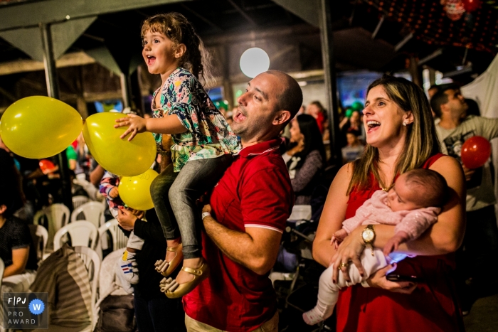 Une mère tient son bébé endormi pendant que le père tient sa fille en liesse dans cette photo primée de l’Association de photojournalistes de famille par un photographe de famille du documentaire de Rio de Janeiro.