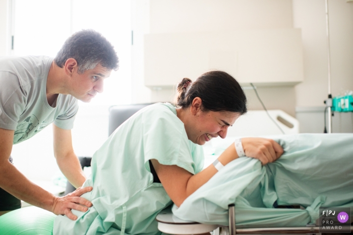 Un mari soutient sa femme lors de l'accouchement à l'hôpital dans cette image prise par un photographe de naissance documentaire du Minas Gerais.