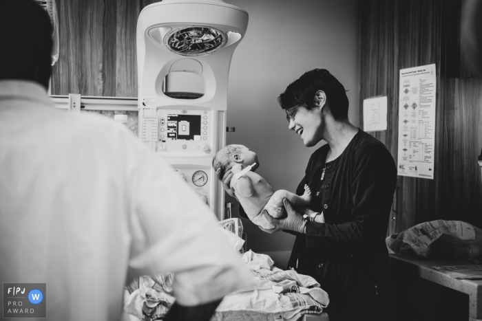 Photo by: <a href="https://www.fpja.com/documentary-family-photography-contests/melissa-ludwig/new-jersey/2072171">Melissa Ludwig - United States</a> A mother holds her newborn baby in this hospital in this black and white photo by a New Jersey birth photographer.