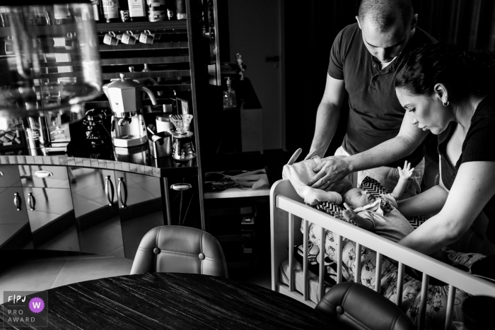 Photo by: <a href="https://www.fpja.com/documentary-family-photography-contests/gustavo-neumann/rio-grande-do-sul/2074376">Gustavo Neumann - Brazil</a> A mother and father put their baby in a crib in this black and white photo by a Rio Grande do Sul, Brazil family photojournalist.