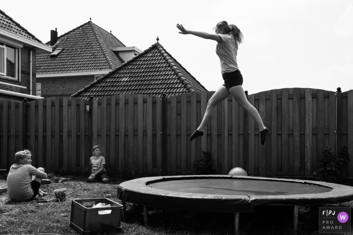 Photo by: <a href="https://www.fpja.com/documentary-family-photography-contests/liesbeth-parlevliet/zuid-holland/2074691">Liesbeth Parlevliet - Netherlands</a> Two young boys watch their mother jumping on a trampoline in this black and white photo by a Netherlands family photojournalist.