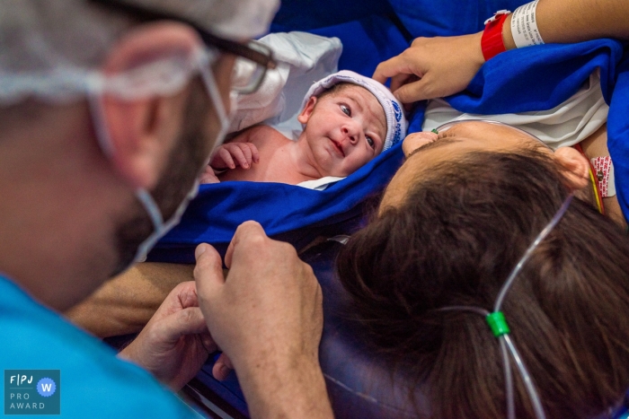 Photo by: <a href="https://www.fpja.com/documentary-family-photography-contests/ta%C3%ADs-motta/campinas/2075701">Taís Motta - Brazil</a> A mother and father get to meet their newborn for the first time in the hospital in this photo by a Sao Paulo birth photographer.