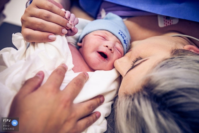 Photo by: <a href="https://www.fpja.com/documentary-family-photography-contests/gab-campello/s%C3%A3o-paulo/2077136">Gab Campello - Brazil</a> A woman holds and kisses her newborn for the first time in this photo by a Sao Paulo, Brazil birth photographer.