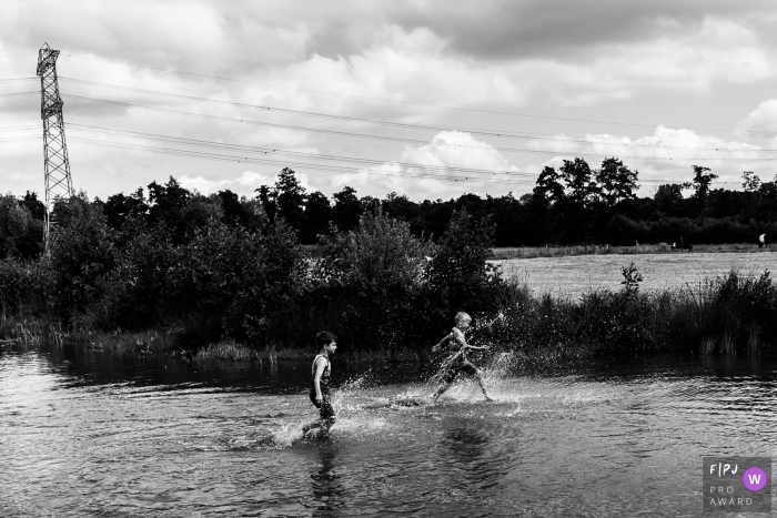 Photo by: <a href="https://www.fpja.com/documentary-family-photography-contests/christie-agema/zwolle/2079466">Christie Agema - Netherlands</a> Two boys splash through water in this award-winning photo by a Zwolle family photographer.