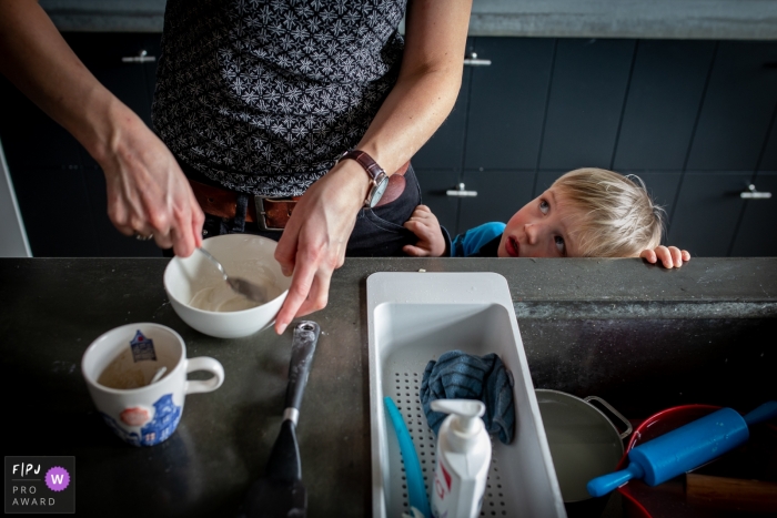 Photo by: <a href="https://www.fpja.com/documentary-family-photography-contests/annemiek-kinneging/drenthe/2079781">Annemiek Kinneging - Netherlands</a> A little boy watches as his mother does the dishes in this photo by a Drenthe, Netherlands award-winning, documentary-style family photographer.