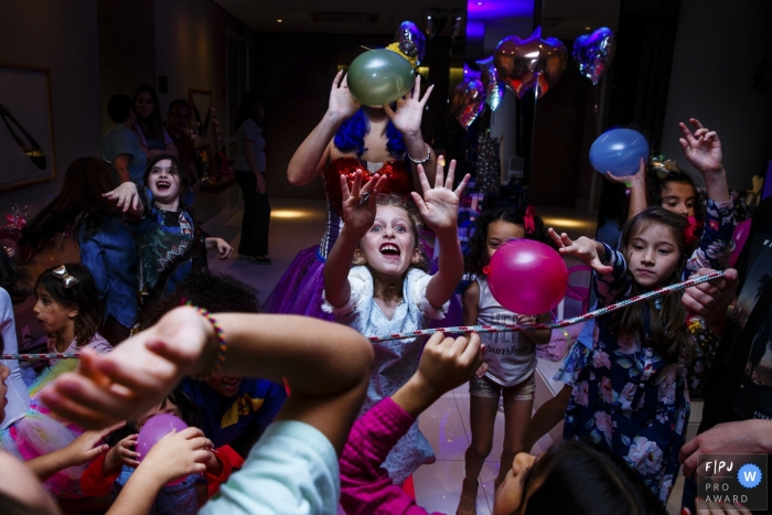 Photo by: <a href="https://www.fpja.com/documentary-family-photography-contests/graziela-ventura/s%C3%A3o-paulo/2080096">Graziela Ventura - Brazil</a> A large group of children run around playing with balloons in this photo by a Sao Paulo, Brazil award-winning family photographer.