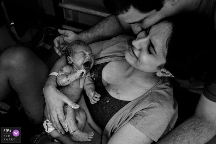 Une mère et un père à l'hôpital tiennent leur bébé pour la première fois sur cette photo en noir et blanc réalisée par un photographe de naissance, Pernambouc, à Recife.