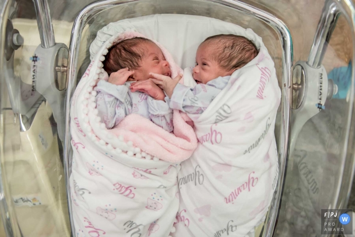 Photo by: <a href="https://www.fpja.com/documentary-family-photography-contests/alessandra-corveloni/rio-de-janeiro/2080646">Alessandra Corveloni - Brazil</a> Newborn twins lay together in the hospital in this picture by a Rio de Janeiro, Brazil birthing photographer.